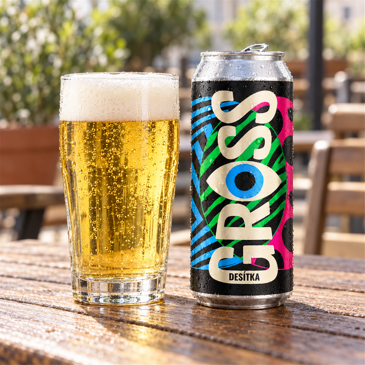 GROSS Desitka servida en vaso: lager dorada pálida y transparente con espuma blanca, junto a su lata en una terraza
