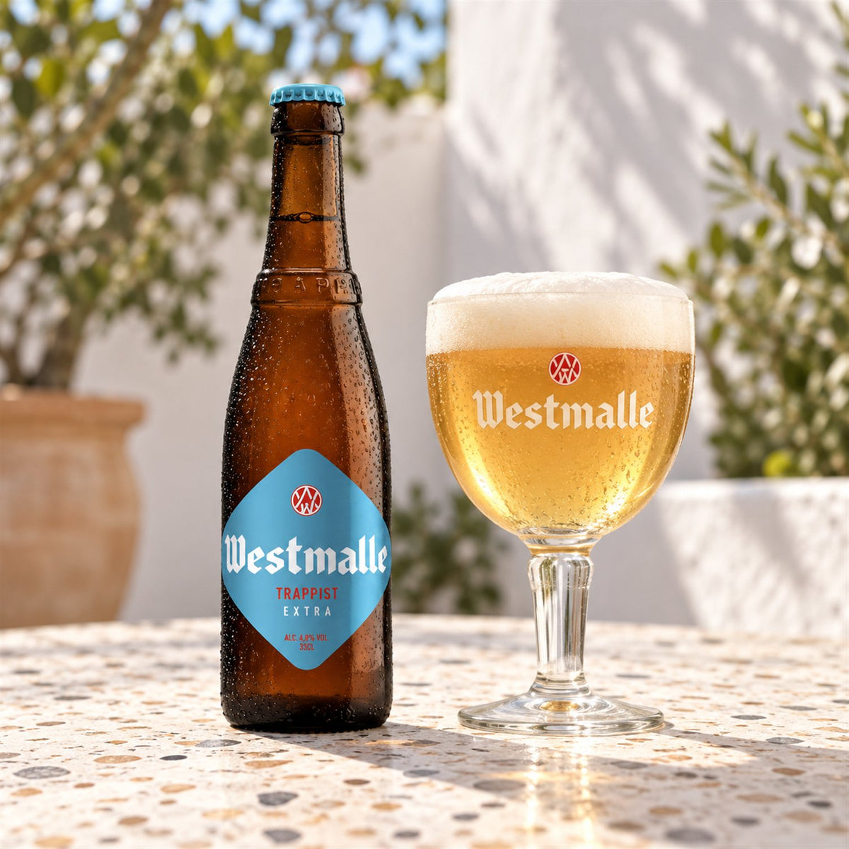 Westmalle Extra: bebida servida en vaso junto a su envase